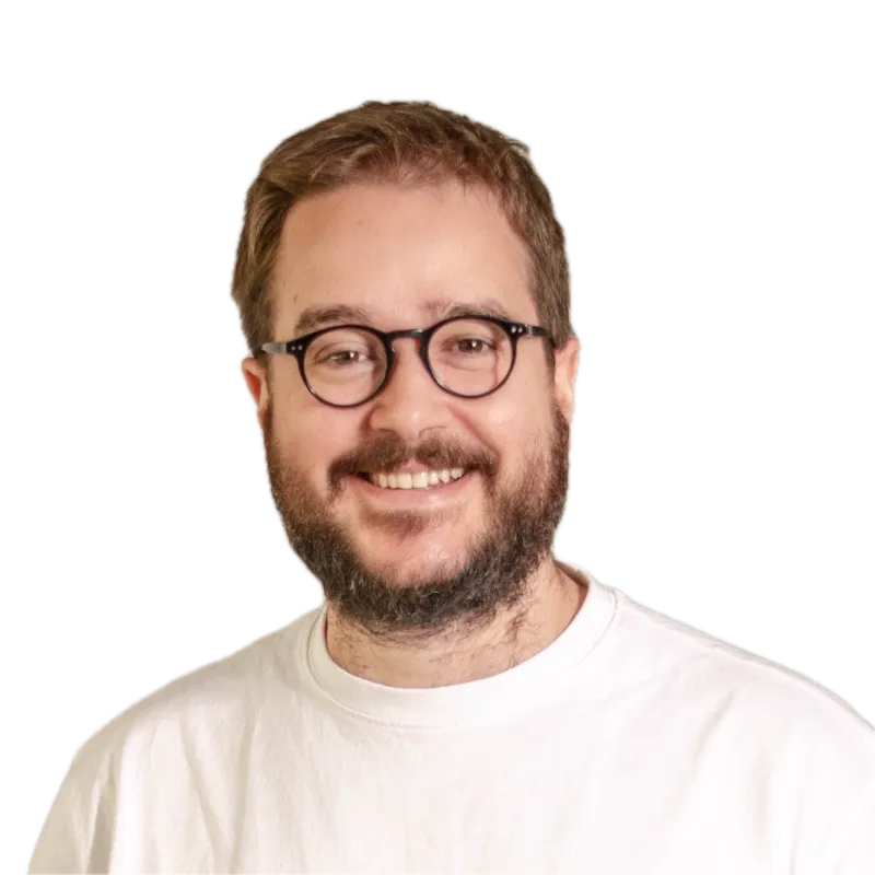 Oriol Piqué, programador de software a mida amb IA, somrient amb ulleres i samarreta blanca